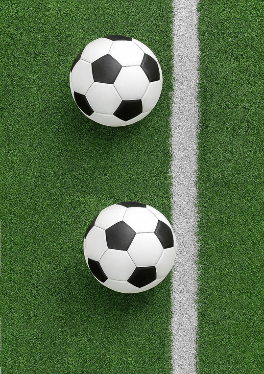 Two footballs, one over the line, the other nearly over the line.