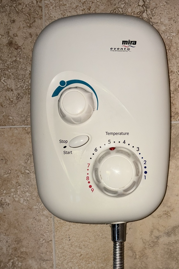 Electric shower on tiled wall