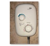 electric shower on brown tiled wall